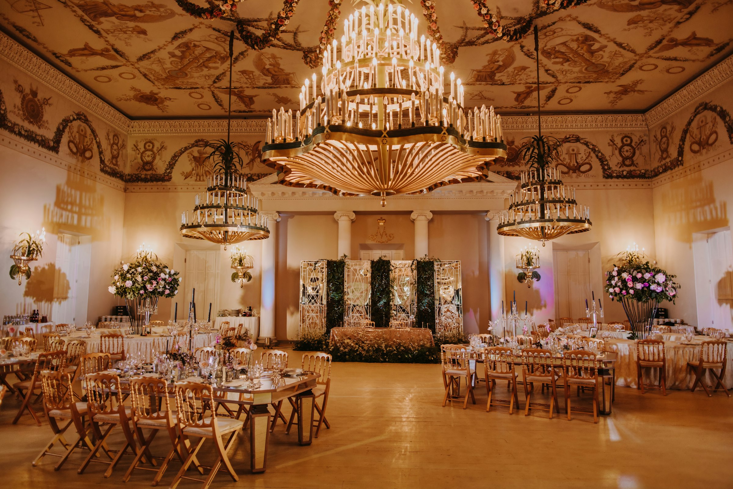 Ornate banquet hall lit by rows of chandeliers